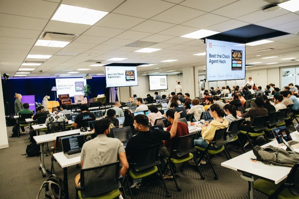 Hackers building at long tables during Beat The Clock Agent Hack